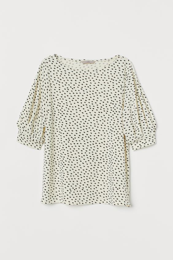 Top blanco de manga corta con lunares negros efecto mancha. De H&M. (9,99 euros).