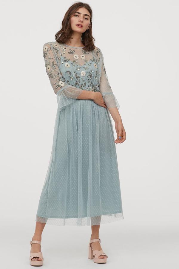 Este precioso vestido azul que no está disponible en tiendas tiene corte midi y un cuerpo bordado de cuentas y lentejuelas sobre una malla que continúa en la falda con vuelo. Con mangas tres cuartos acabadas en volante y costura elástica en la cintura, cuesta 49,99 euros. Solo queda en las tallas 36, 38 y 40, aunque esta última se está agotando.