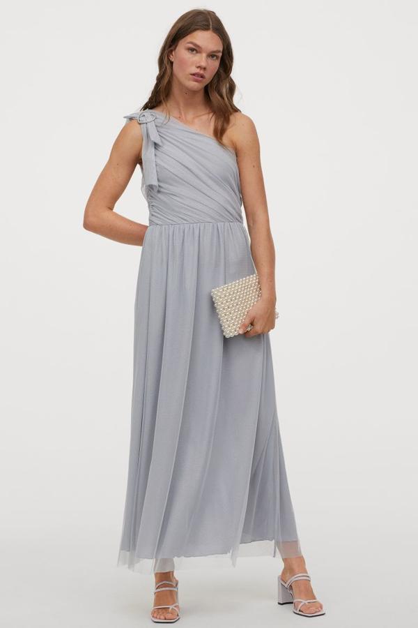 Con un hombro libre y en tul brillante de poliéster reciclado, este vestido azul grisáceo es ideal para aquellas que apuesten por los cortes más clásicos. Con un bonito cierre de cuentas en el hombro, cuesta 49,99 euros, solo se vende en la web y se está agotando en as tallas 48 y 50.