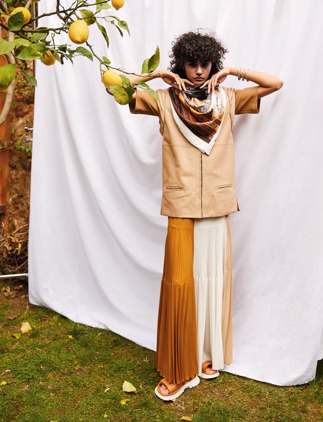 Chaleco, falda y sandalias, todo de Givenchy.Camiseta de Max Mara, pañuelos de Hermès y pulseras de Tous.