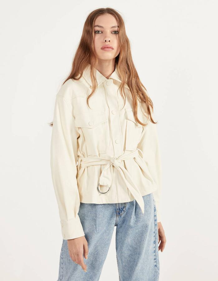 Modelo corto, con cinturón y en color crudo de Bershka (35,99 euros). Disponible también en mostaza y negro.