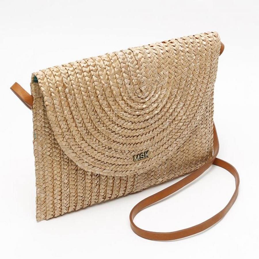 En formato tipo sobre, esta bandolera en rafia sintética de Misako es una de nuestras favoritas. El asa larga viene en color marrón claro y cuesta 16,99 euros.