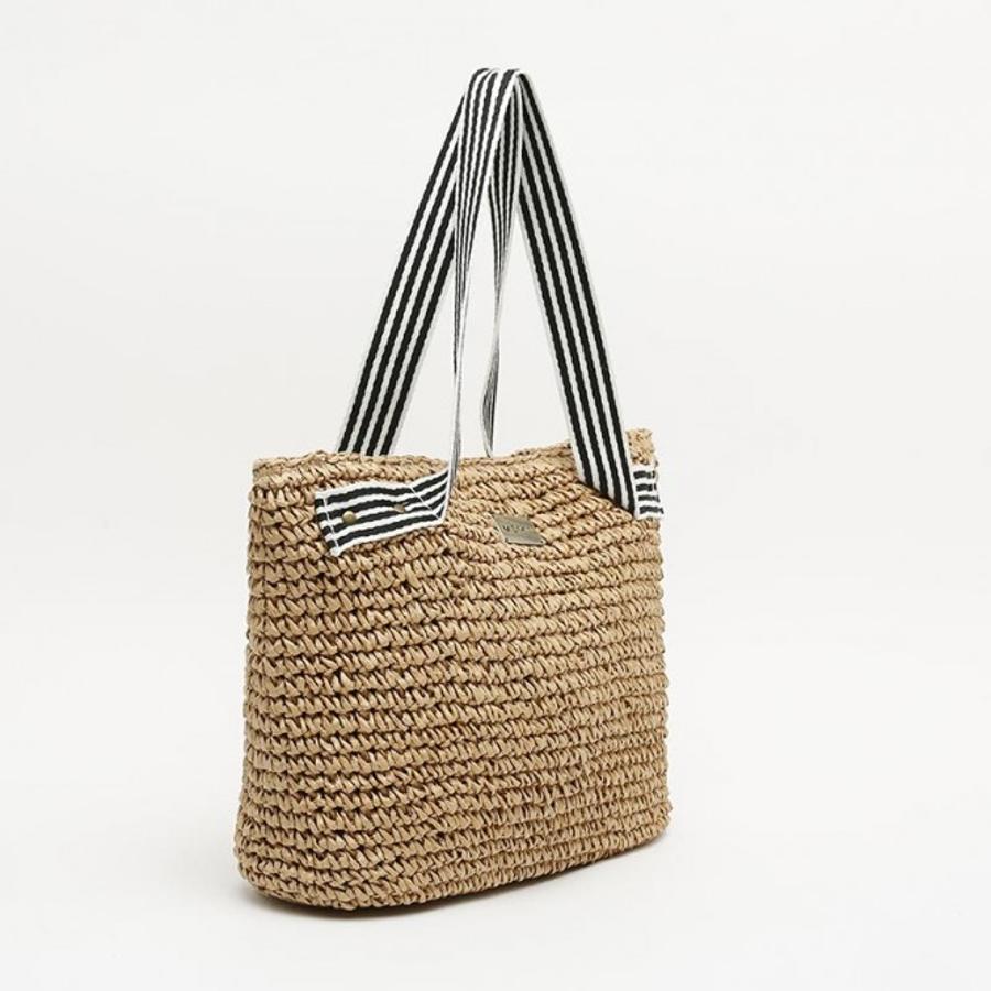 Otro shopper perfecto para los estilismos más frescos es este de Misako con aires marineros gracias a sus asas en azul y blanco. Cuesta 27,99 euros.