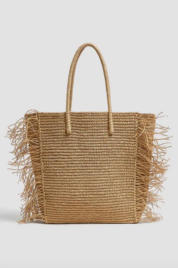 El diseño shopper no podía faltar en los bolsos más veraniegos, y esta propuesta de Pull & Bear viene con flecos laterales incorporados. Cuesta 25,99 euros.