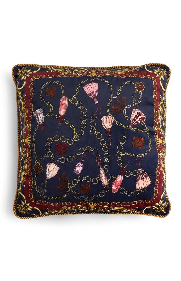 Dale otro aire a tu sillón o cama con un cojín cuadrado azul como este, con estampado de cadenas. Cuesta 8 euros.