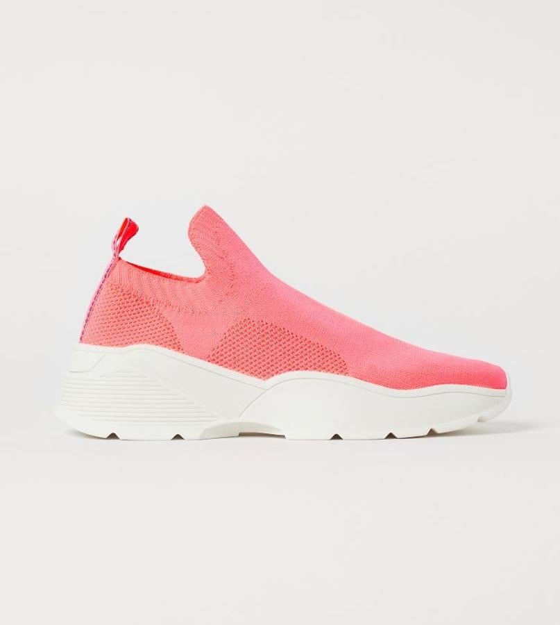 También hay complementos flúor para los estilismos más deportivos. Nos quedamos con esta zapatilla efecto calcetín de H&M en rosa (24,99€).