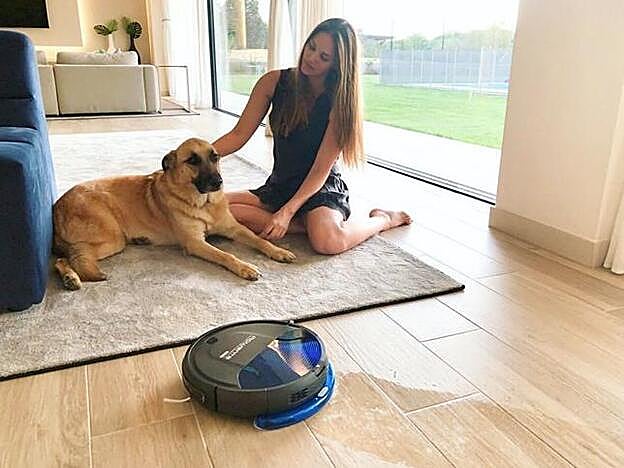 El salón, dividido en dos ambientes, tiene suelos de madera y grandes ventanales.