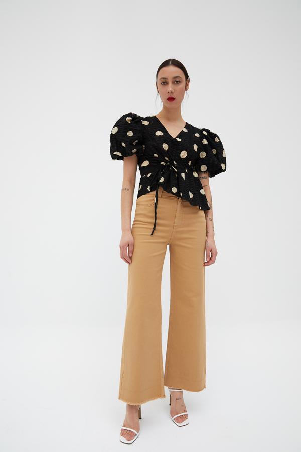 Con fondo negro y lunares beige, este cuerpo de manga abullonada y tejido con efecto fruncido cuesta 29,99 euros y está disponible en las tallas S, M y L.