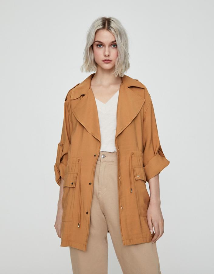 Disponible en verde, crudo y anaranjado, esta sahariana con cordón ajustable en la cintura y bolsillos con solapa puede ser tu comodín más cómodo para esas jornadas de entretiempo. De 29,99 euros ha pasado a 14,99 euros, y está disponible entre las tallas XS y XL.