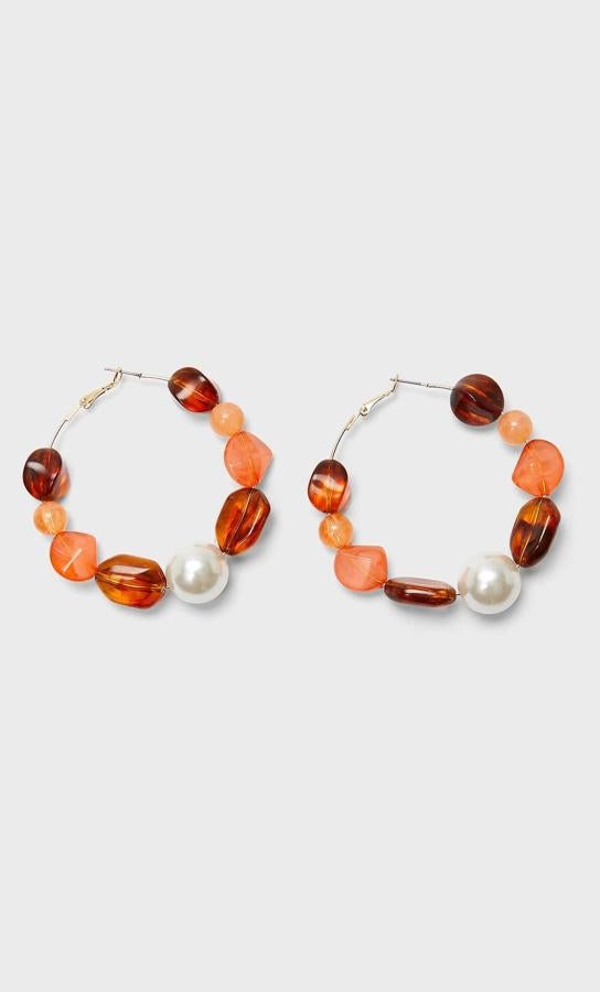 Stradivarius apuesta por los aros de piedras naturales en tonos tierra y ámbar que, en este caso, mezclan también con perlas. Su precio es insuperable, cuestan 7,99 euros.