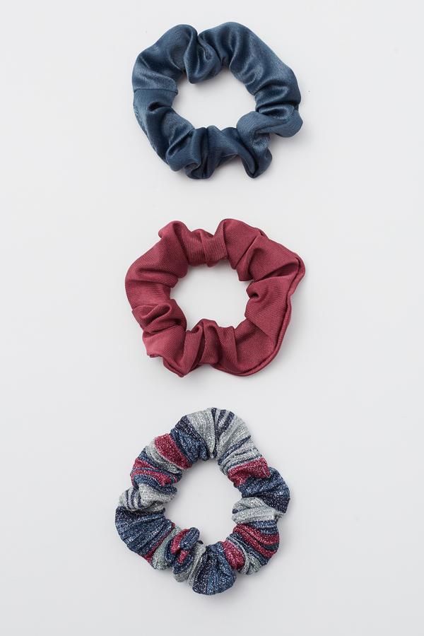 Paquete de tres coleteros en tres texturas diferentes y en tonos granate y azul, de Sfera (3,99 euros).