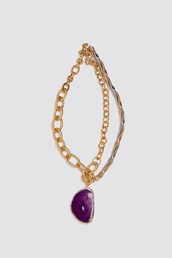 No podrás resistirte a este increíble collar metálico que combina una cadena con eslabones lisos y otros labrados con un colgante de piedra natural en tono morado. Su precio es de 22,95 euros.