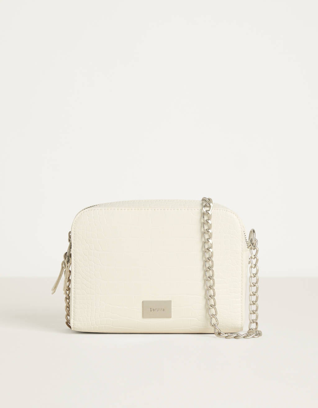La versión más clásica, y más básica, del bolso blanco la hemos encontrado en Bershka por 15,99 euros y con asa larga de cadena.