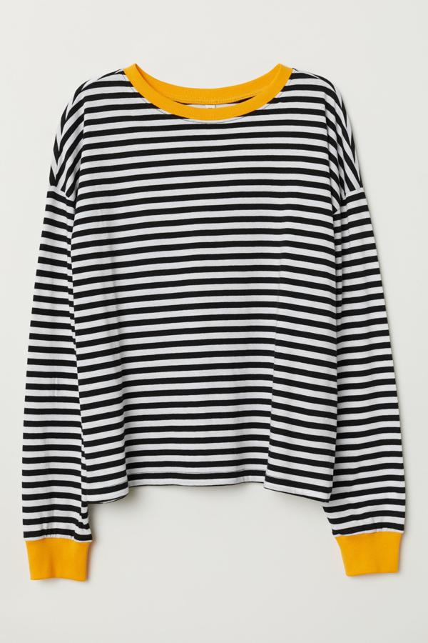 En H&M encontramos esta camiseta de punto de manga larga con rayas en blanco y negro (también tienes la opción de las rayas en rosa), y cuello y puños en amarillo. Tiene un precio de 7,99 euros.