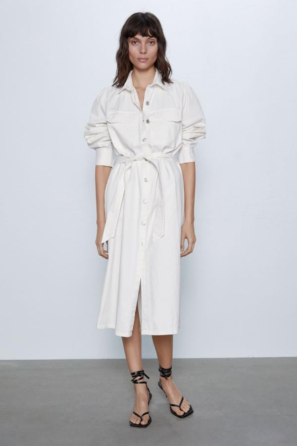 Con cuello y solapa, este vestido midi denim en color crudo de Zara cuenta con bolsillos en pechera y laterales y cierre frontal con botones metálicos y cinturón. Está disponible de la talla XS a la XXL y tiene un precio de 39,95 euros.