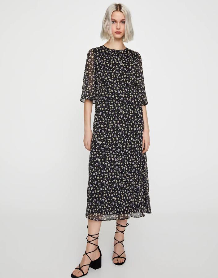 En color negro y con pequeñas flores de colores, este vestido de Pull & Bear con espalda abierta y manga francesa tiene un precio de 29,99 euros y está disponible desde la talla XS a la L.