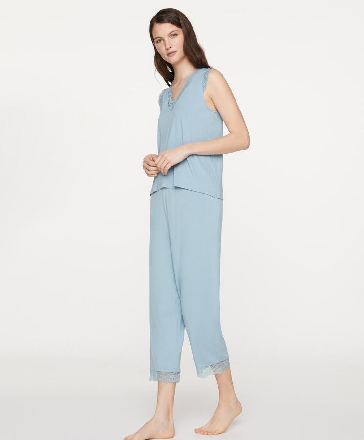 En color azul, Oysho nos propone este pijama de pantalón largo con detalle de blonda en la parte final, disponible de la talla S a la XL y con un precio de 17,99 euros. La camiseta sin mangas, y con escote de pico y blonda del mismo color, cuesta 15,99 euros.