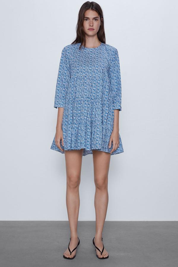 En color azul, este vestido corto de cuello redondo y manga por debajo del codo, tiene un bajo acabado en volante y está disponible, por 15,99 euros, en todas sus tallas (de la XS a la XXL).