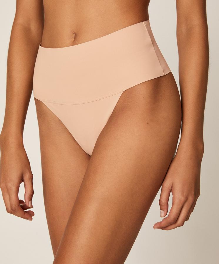 Con un precio de 7,99 euros y disponible en color piel y en negro, este tanga de Oysho con cintura alta y confeccionado en tejido de microfibra es uno de los mejores aliados para que tu ropa interior no se marque bajo la ropa.