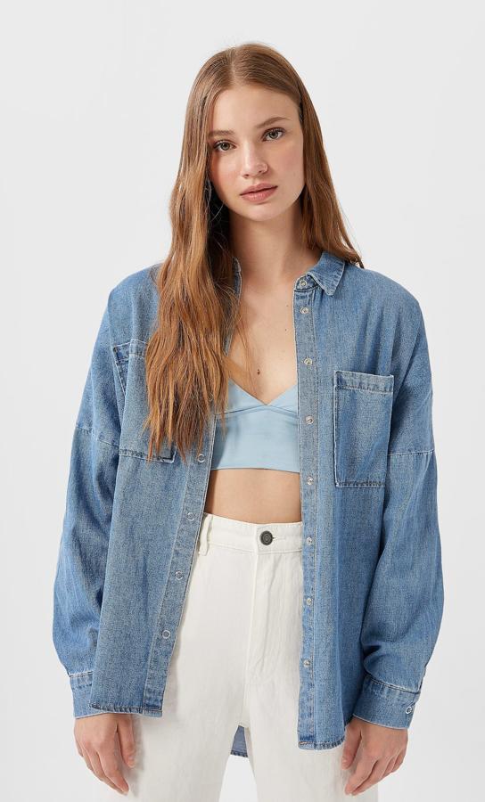 Para llevar de sobrecamisa o abrochada; por dentro o por fuera del pantalón, este modelo denim fluido es de Stradivarius (19,99 euros).