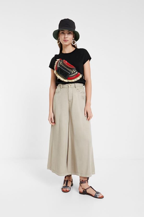 Si hay un accesorio de los 90 que ha vuelto con más fuerza todavía que en aquella década es la riñonera.  Esta es de lo más original , inspirada en las piezas de la tribu africana masai. Y lleva escrito un claro mensaje en la parte delantera: love (69,95 euros).