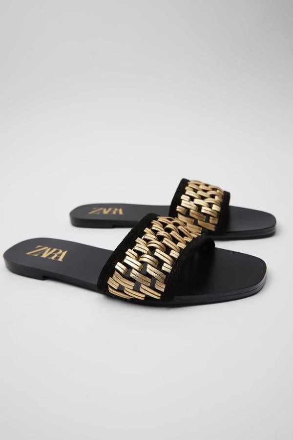 Otra de las propuestas de Zara es este precioso trenzado dorado en el empeine de estas sencillas sandalias en color negro. Cuestan 29,95 euros y está disponible entre los números 35 y 42.