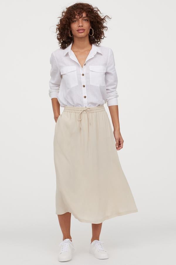 En viscosa, con cordón de ajuste y bolsillos en las costuras laterales, esta falda de H&M que también ha lanzado en estampado negro, cuesta 24,99 euros y está disponible entre las tallas XS y XL.