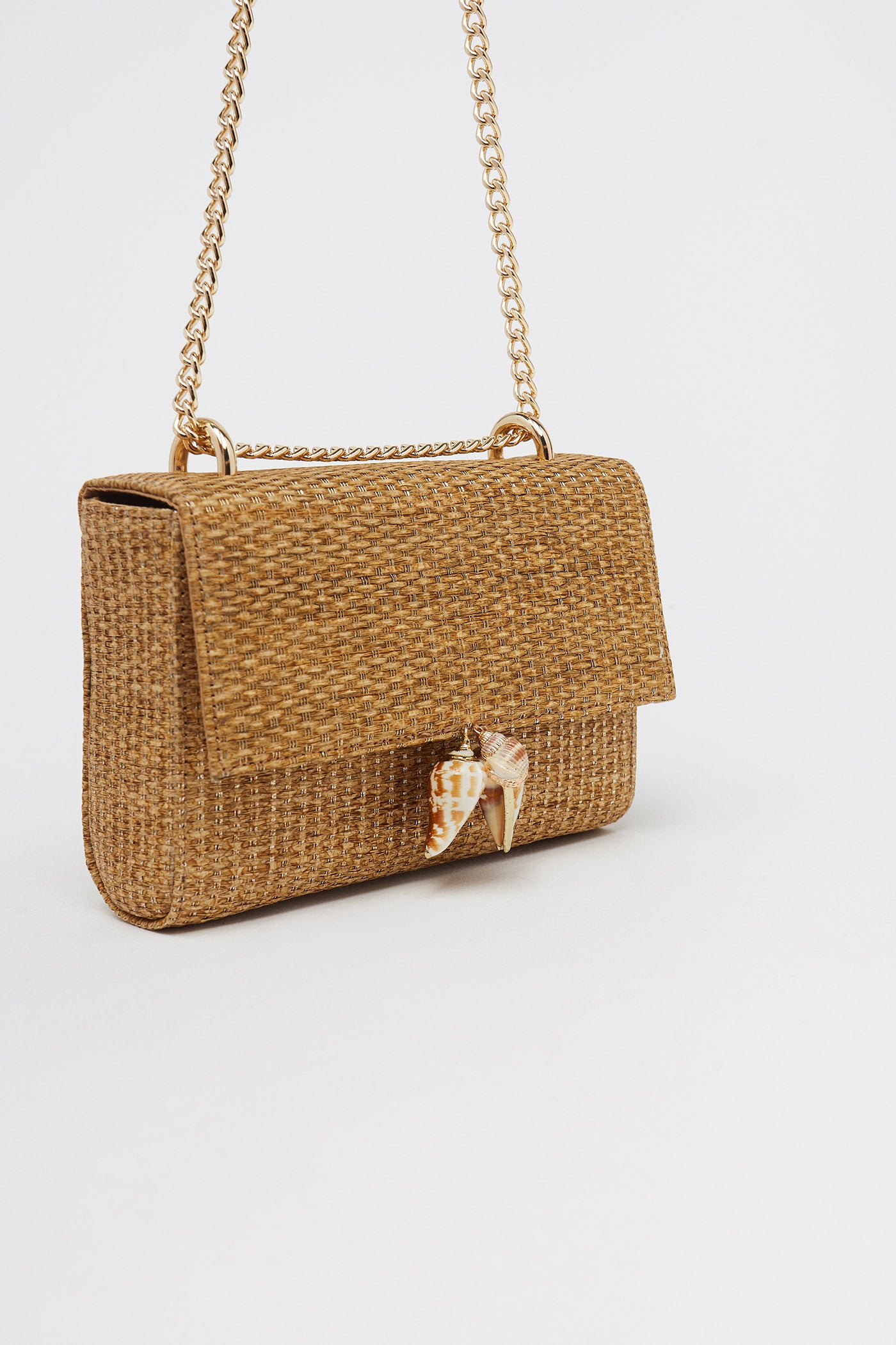 Bolso tipo bandolera con tejido de hilo metalizado, cadena y detalles de conchas marinas. Ideal para el verano 2020 y para todos los veranos. De Sfera. (16,99 euros).