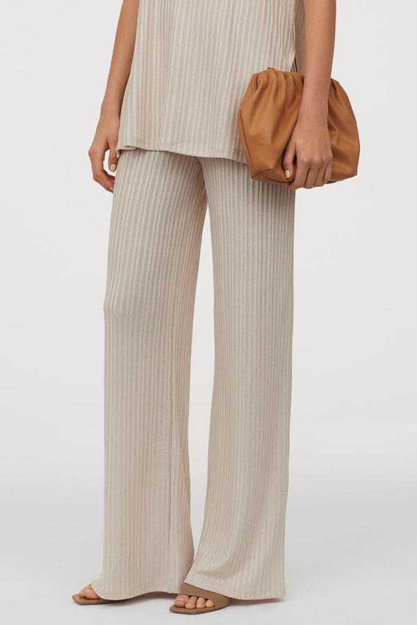 H&M es una de las firmas que más ha apostado por los pantalones de punto, y entre todos ellos hemos encontrado este tobillero en punto vaporoso de canalé. Con talle alto y perneras amplias rectas, cuesta 19,99 euros y está disponible entre las tallas S y XXL.