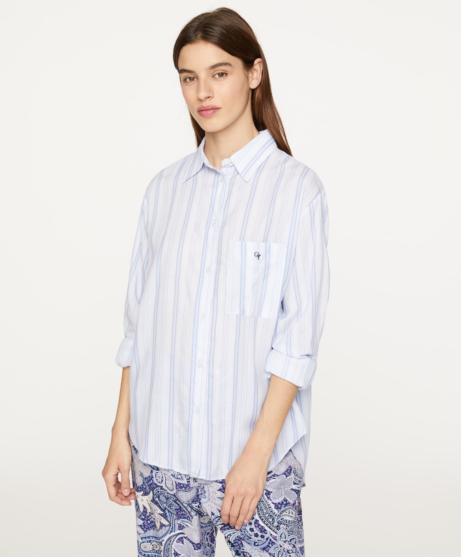 Camisa de pijama de manga larga con estampado de rayas en azul y bolsillo delantero con logo de Oysho. (22,99 euros).