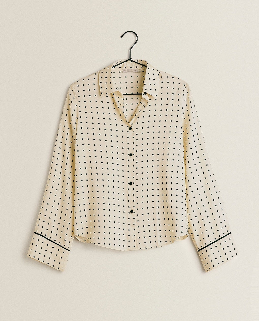Los lunares son ya un clásico en las camisas pijameras. Esta opción en tono crema y topos negros de Zara Home es perfecta para sentirse guapa y estar cómoda en casa. (29,99 euros).