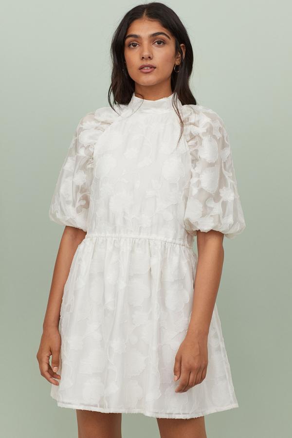 Con flores superpuestas en la tela y un corte que sienta como un guante, este vestido mini de jacquard en blanco es de H&M (39,99 euros).