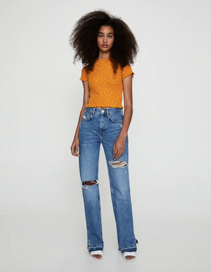 En tejido cuadrillé, con cuello redondo y lunares en color blanco, esta camiseta de Pull&Bear con acabados rizados tiene un precio de 7,99 euros y está disponible entre las tallas XS y L.