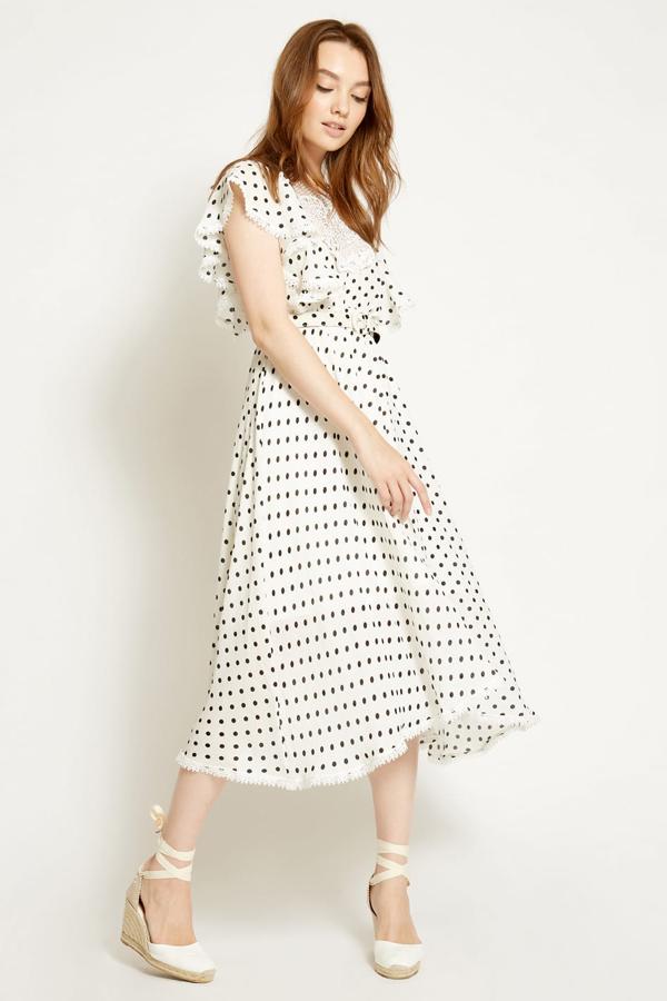 Este vestido de corte midi en color blanco con topos en negro será uno de tus grandes aliados esta primavera. Con volante en la manga y detalle de encaje en la zona del cuello, está rebajado desde los 120 euros hasta los 36 euros.