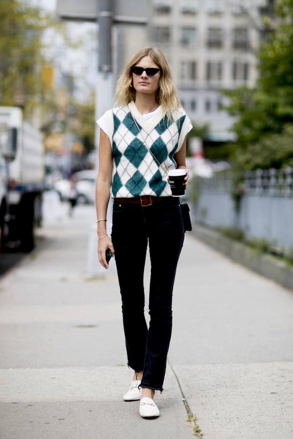 Los vaqueros negros con el bajo deshilachado quedan así de bien con un chaleco de punto y unos mocasines. Un estilo preppy que nunca pasa de moda.