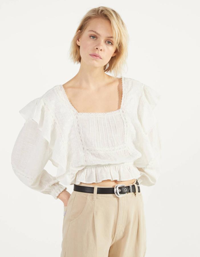 Blusa blanca con volantes y bordados, de Bershka (25,99 euros).