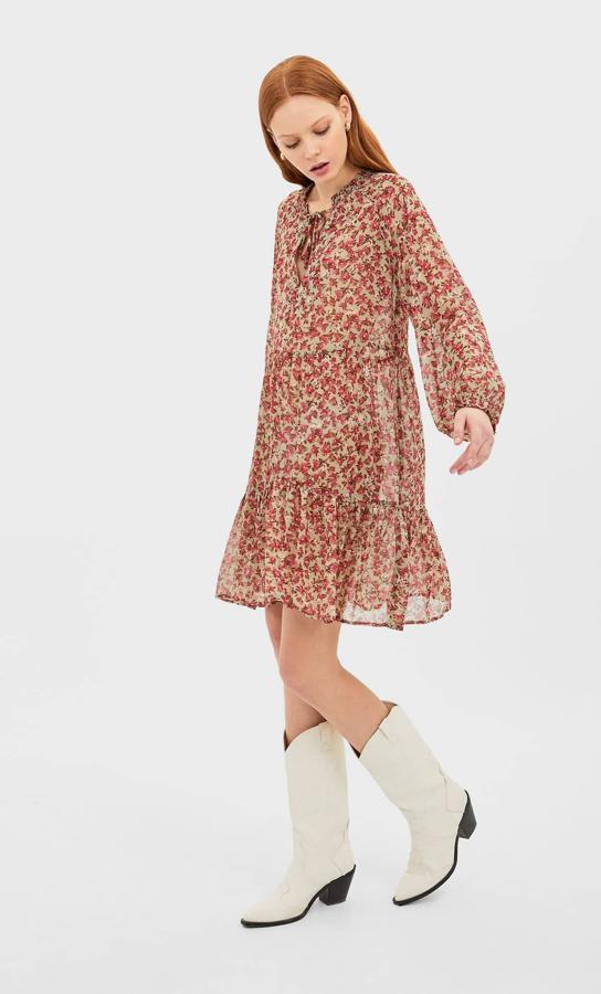 Confeccionado con tejido transparente con forro, este bonito vestido de fondo beige con flores rojas es de Stradivarius y tiene un precio de 19,99 euros. Está disponible en las tallas S, M y L.