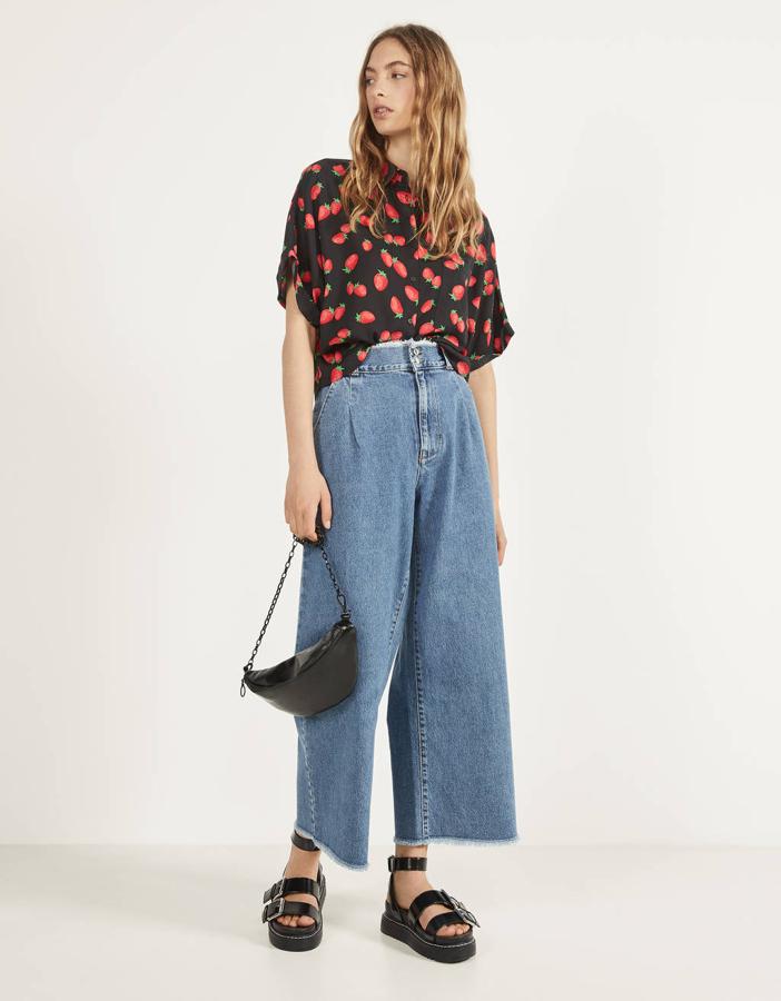 Una de nuestras propuestas favoritas es esta camisa de Bershka en color negro con estampado de fresas. Cuesta 15,99 euros y solo queda en las tallas S y L, aunque esta última está agotándose.