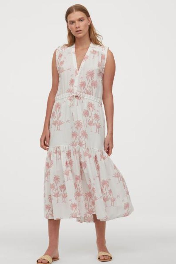 Vestido de algodón blanco con palmeras en rosa, escote en pico y tira ajustable en la cintura, de Desmond & Dempsey para H&M (39,99 euros).