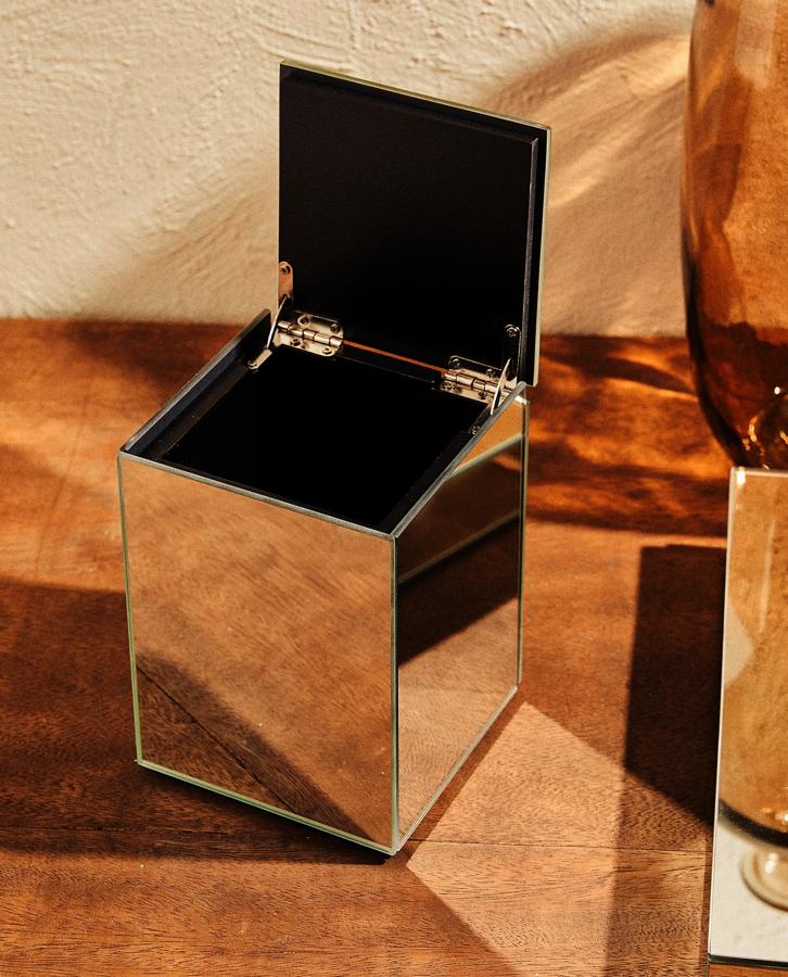 Como si de un joyero se tratase, esta caja de vidrio y madera con forma de cubo y cubierta de espejos tiene un precio de 12,99 euros.