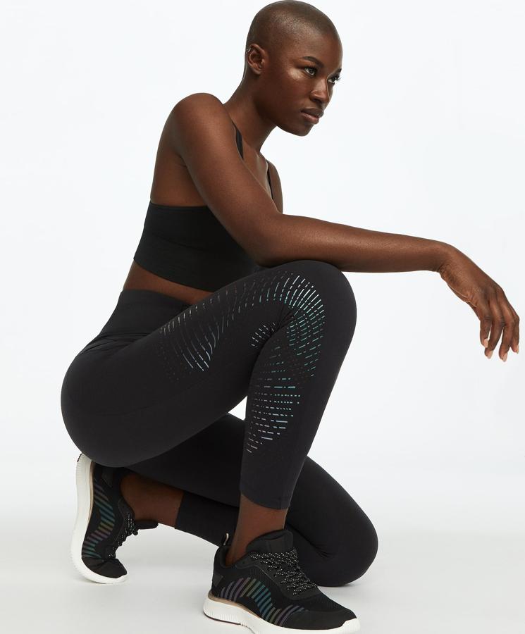 Oysho nos propone estos leggings largos de compresión con cintura alta y tejido moldeador. Cuenta con un bolsillo en la parte trasera y detalles iridiscentes a lo largo de ambas piernas. Tiene un precio de 35,99 euros.