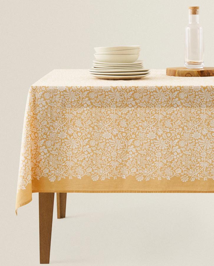 Este mantel de algodón en color amarillo (también disponible en azul) con estampado de hojas y ramas, tiene unas medidas de 150 x 200 centímetros y cuesta 19,99 euros.