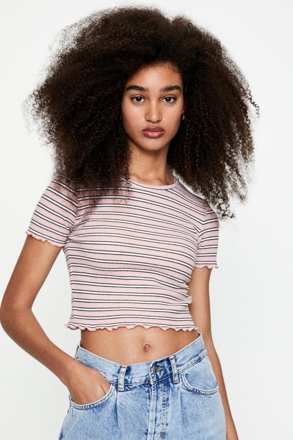 Con un precio de 5,99 euros, esta camiseta de manga corta, disponible en numerosos colores, cuenta el detalle de pequeños rizos en la manga y en el bajo.