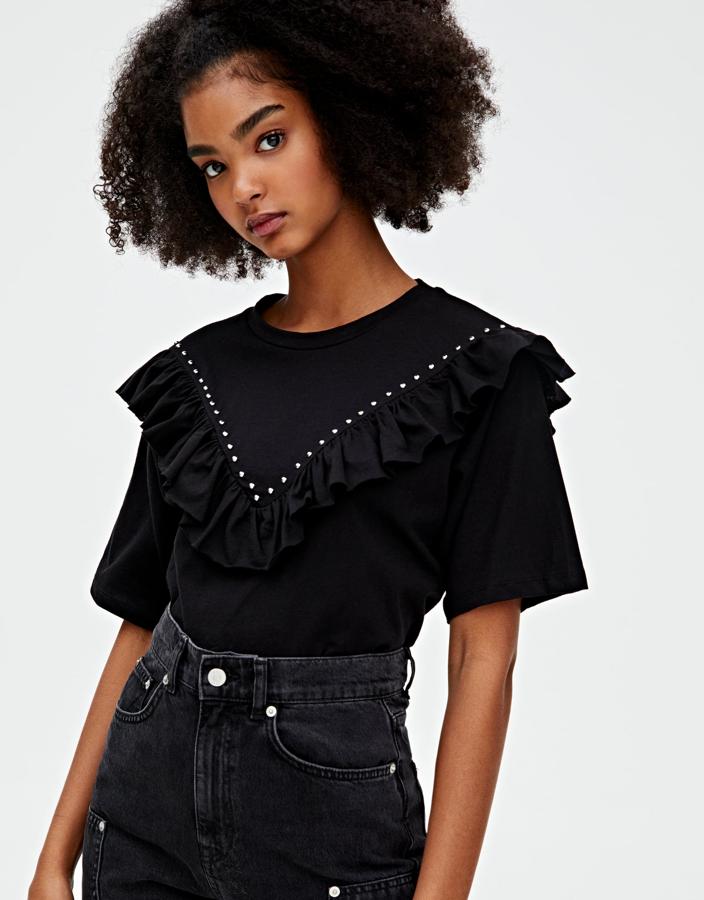 Esta camiseta en color negro con detalle de volante y tachas a la altura del pecho tiene un precio de 12,99 euros y combina con todo.