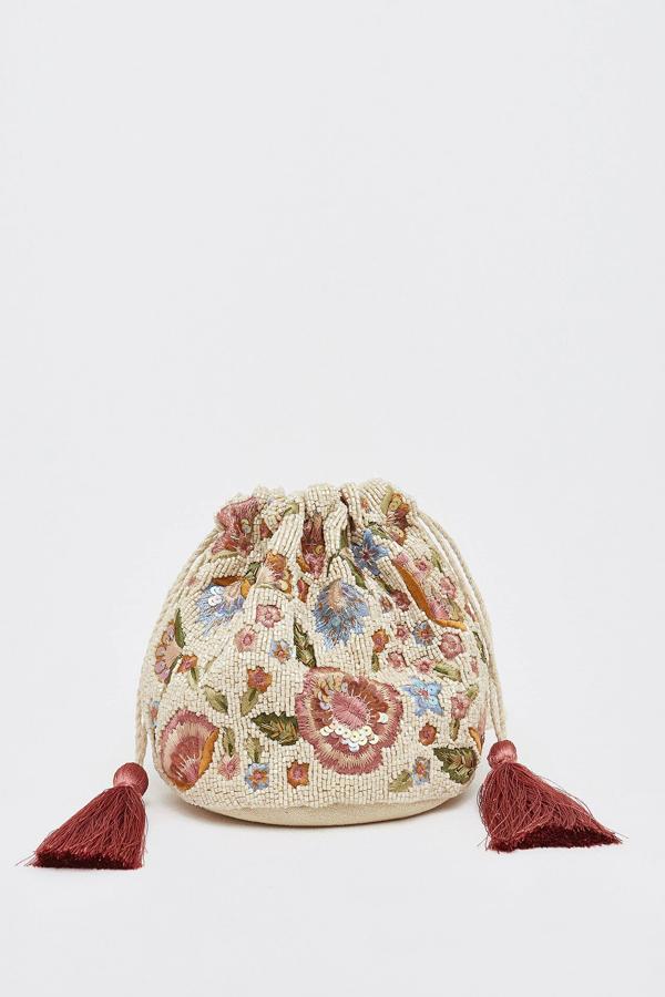 Este bolso bandolera con forma de saco en color crema tiene detalles de abalorios en forma de flor. Con asa larga de cadena, tiene un precio de 11,15 euros.