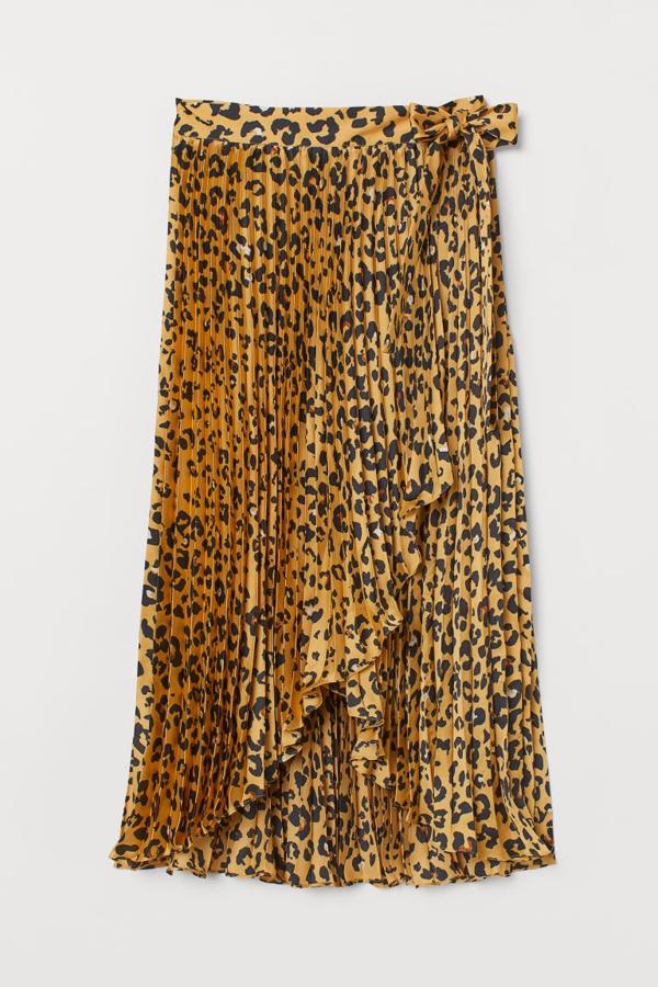 Otra de las propuestas de H&M es esta falda plisada de satén con diseño cruzado con tiras de anudar en un lateral. En estampado de leopardo en color mostaza, tiene un precio de 39,99 euros y está disponible entre las tallas 32 y 46.