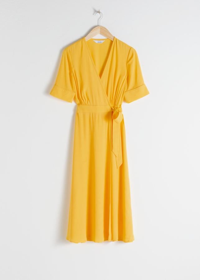 Vestido de manga corta cruzado con lazada, en amarillo oscuro, de & Other Stories (79 euros).