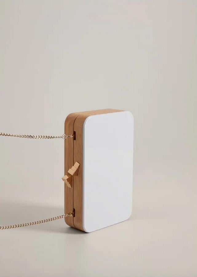 Por su originalidad y combinación de colores, este clutch de Mango es uno de nuestros favoritos. Realizado en madera, que combina con un bonito color blanco, tiene el asa de hombro en color dorado desmontable. Cuesta 39,99 euros.