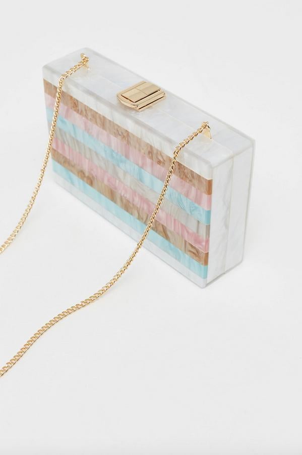 Con asa larga dorada que se puede guardar en el interior, este bolso de mano tipo caja en diseño rígido y estampado de rayas en tonos pastel viene con cierre a presión en color dorado. Es de Sfera y está rebajado, costaba 17,99 euros y ahora podemos comprarlo por 10,75 euros.