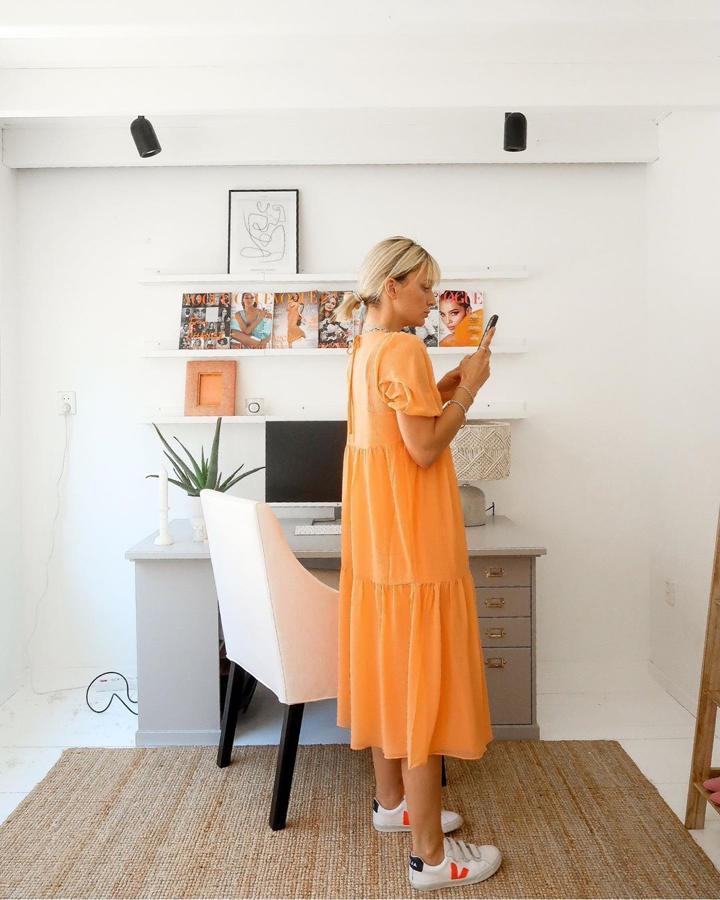 Vestido con zapatillas en uno de los colores que más se llevan este verano, el naranja.